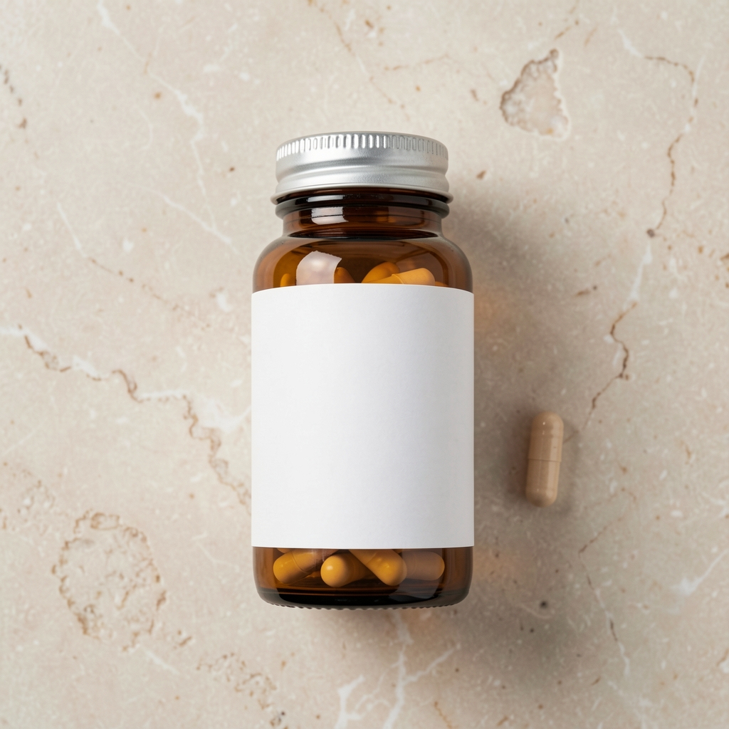 Arkev Core daily supplement bottle in amber glass with white label on a pale stone surface, alongside a single capsule, viewed from above in clean studio lighting